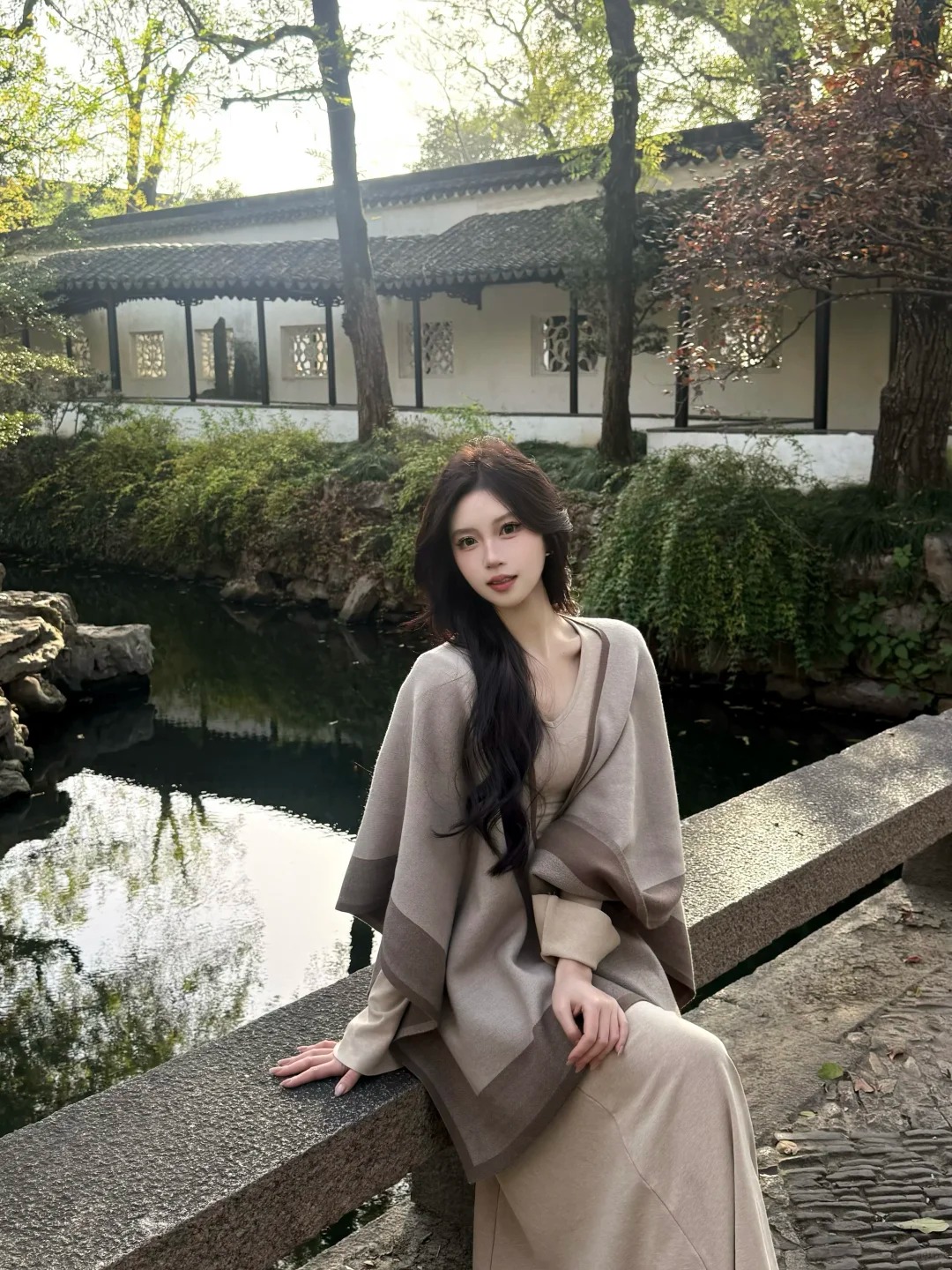 穿长外套的女性倚在庭院栏边